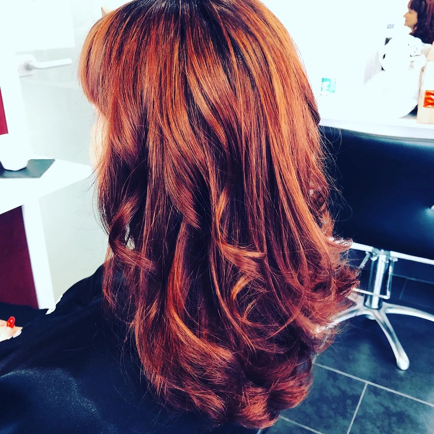 Couleur cuivrée lumineuse sur cheveux longs, réalisée au salon